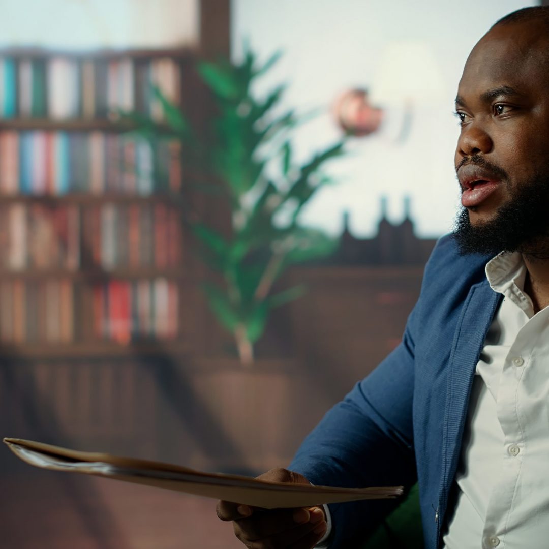 African american agent and his colleague analyzing evidence in a lounge, emphasizing strategic thinking and teamwork to accomplish a surveillance mission. Reading critical documents. Camera B.